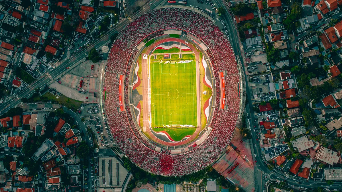 Estádio cheio visto de cima durante um jogo